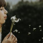 Woman Blowing a Dandelion